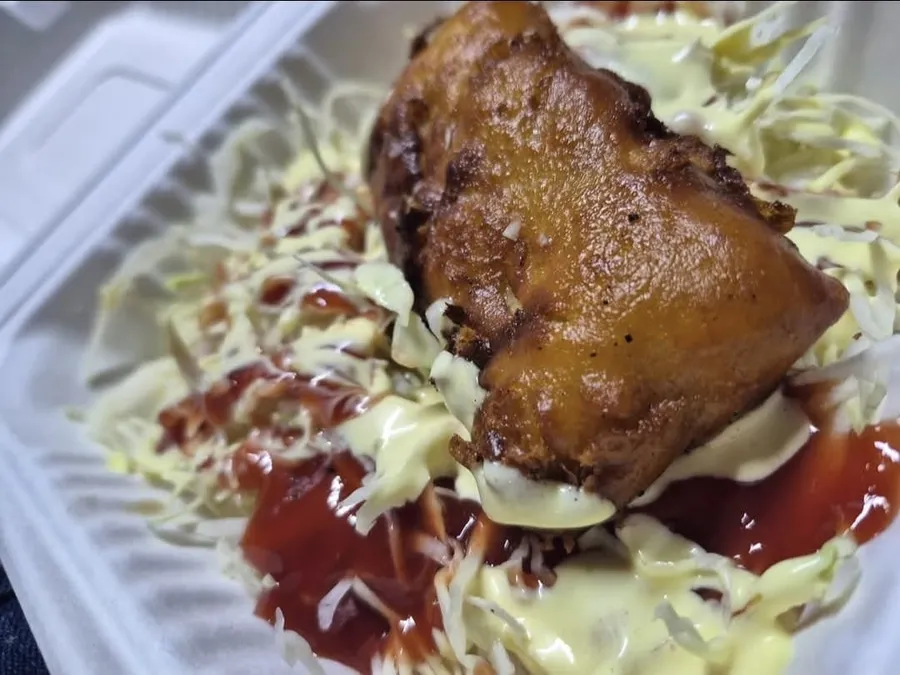 Raviol dorado sobre repollo, con salsa de tomate y mayonesa