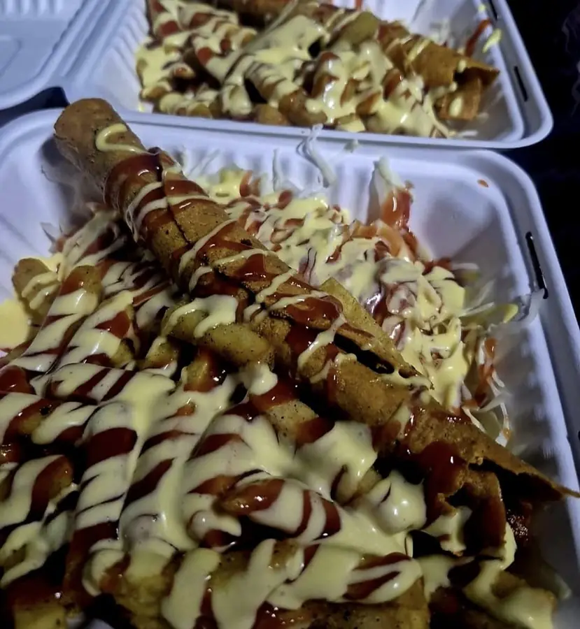 Tacos Cachetón enrollados sobre papas, con repollo y salsas